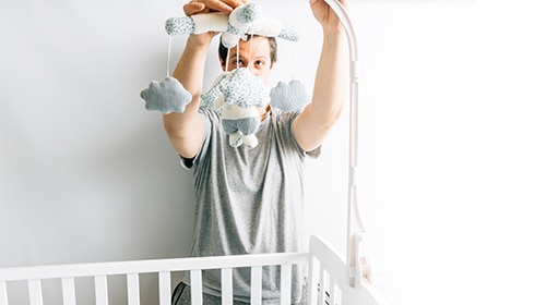 Papá arreglando la cuna del bebé